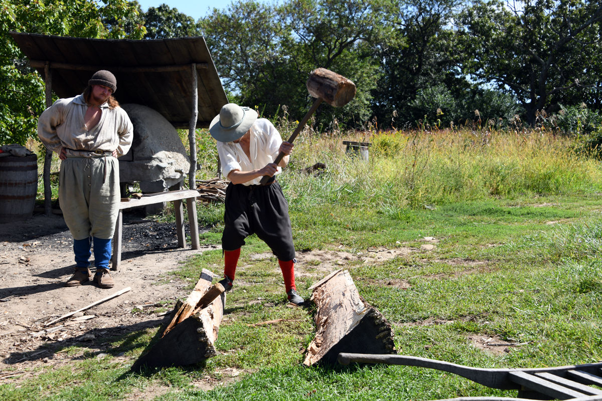 036 The re-enactors use 17th century tools to split a log to make clapboards.jpg